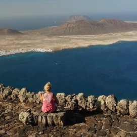 Una turista disfruta de las vistas a La Graciosa desde Lanzarote. Gasto turístico.