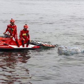 Bomberos del Consorcio junto a los restos de la estructura en la playa de Los Charcos. Foto: Juan Mateos