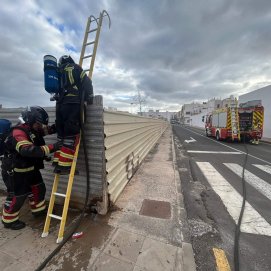 Bomberos en el solar donde se originó el incendio