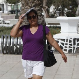 Una mujer se protege del sol durante una ola de calor en Arrecife en 2023. Foto: José Luis Carrasco.