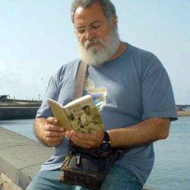 Imagen de archivo del escritor Antonio Félix Martín Hormiga, junto a uno de sus libros en la boca del muelle, en Arrecife