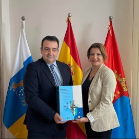 El presidente de la Cámara entrega el documento a la vicepresidenta del Cabildo.