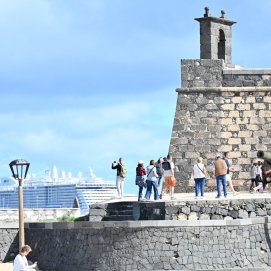 Turistas  en el Castillo de San Gabriel con un crucero al fondo.