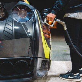 Una persona repostando el tanque del coche en una gasolinera