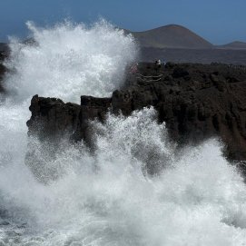 Turistas acercándose a las olas en Los Hervideros