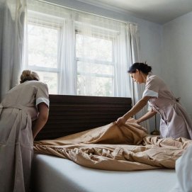 Camareras de piso haciendo una cama en un hotel
