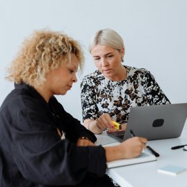 Dos trabajadoras estudian nuevas herramientas digitales. IA.