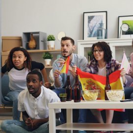 Jóvenes viendo un partido de España en la televisión. supermercados.