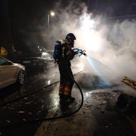 Bomberos sofocando un incendio de contenedores.