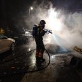 Bomberos sofocando un incendio de contenedores.