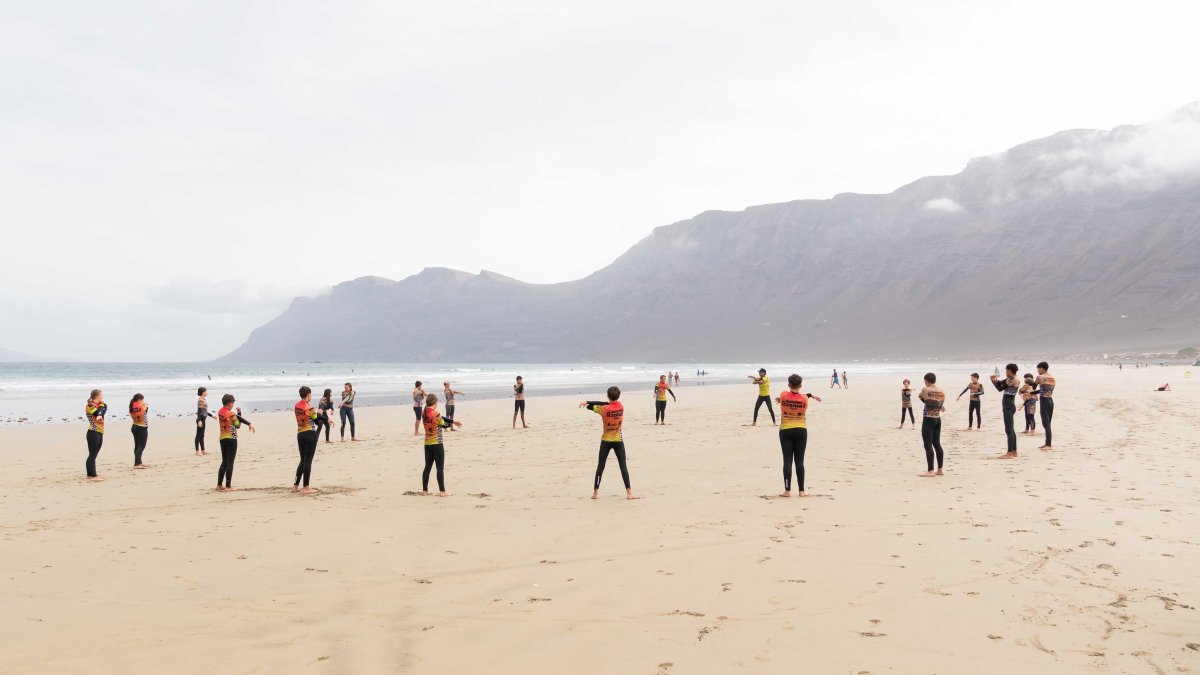 Young people practicing surfing in Famara.
